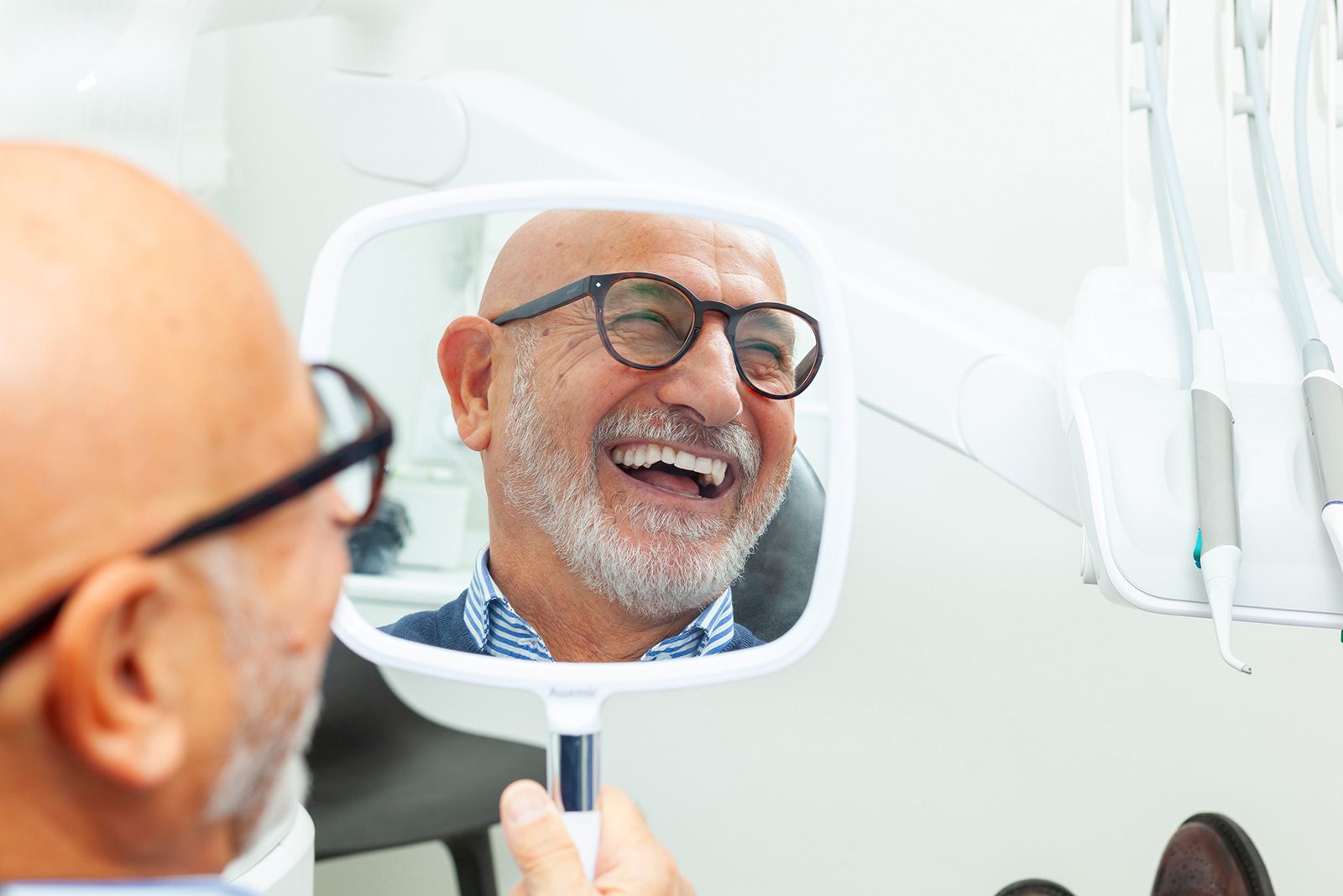 A patient seeing his new smile in the mirror